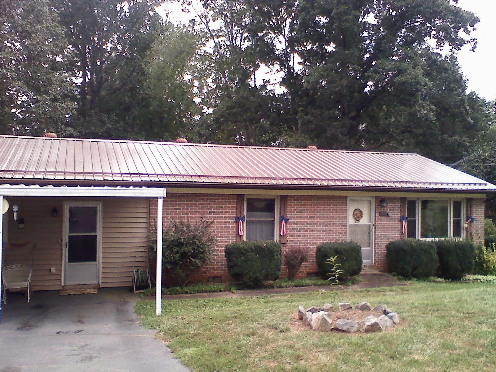 Bronze metal roof and carport on a brick ranch home — Roof Repair work by our crew in Sanderson